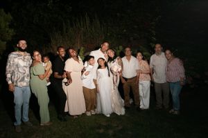 Group photo of wedding guests gathered outside at night.