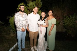 Wedding party posing together outdoors during an evening celebration.