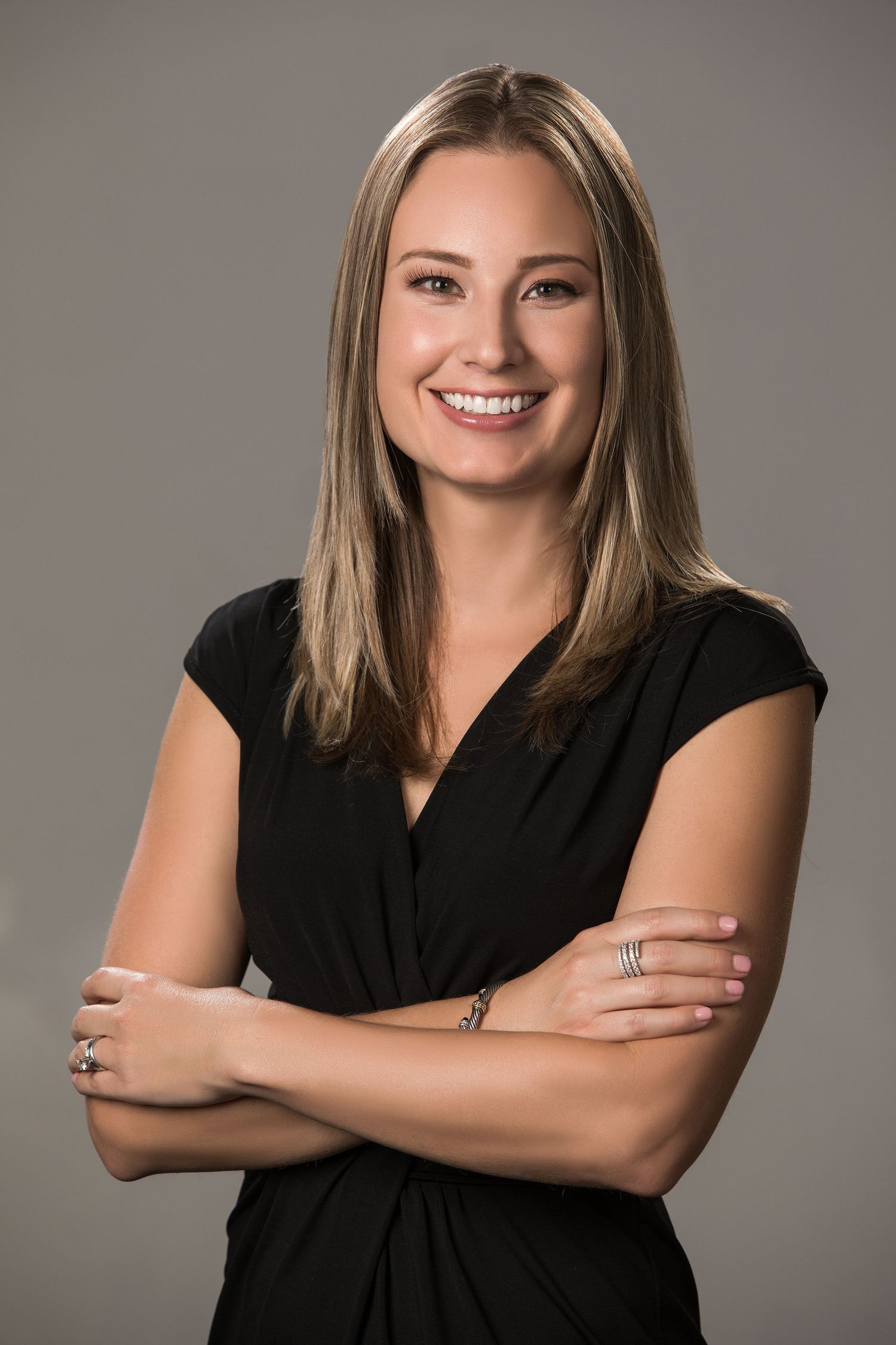 Professional studio portraits of a person in black attire against neutral grey background.