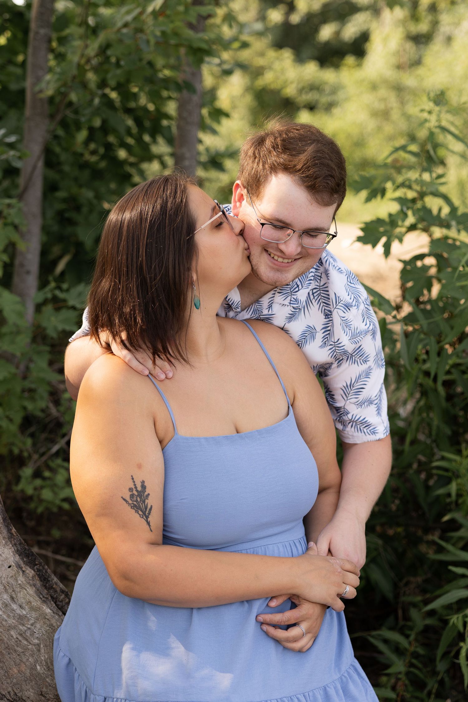 Couple in casual sweatshirts sharing tender moment in natural setting.