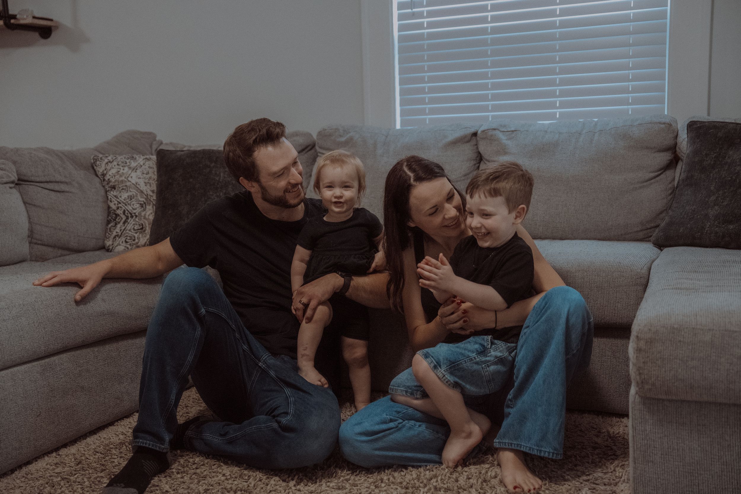 Two people share tender moments on a couch in a series of intimate photographs showing affection and closeness.
