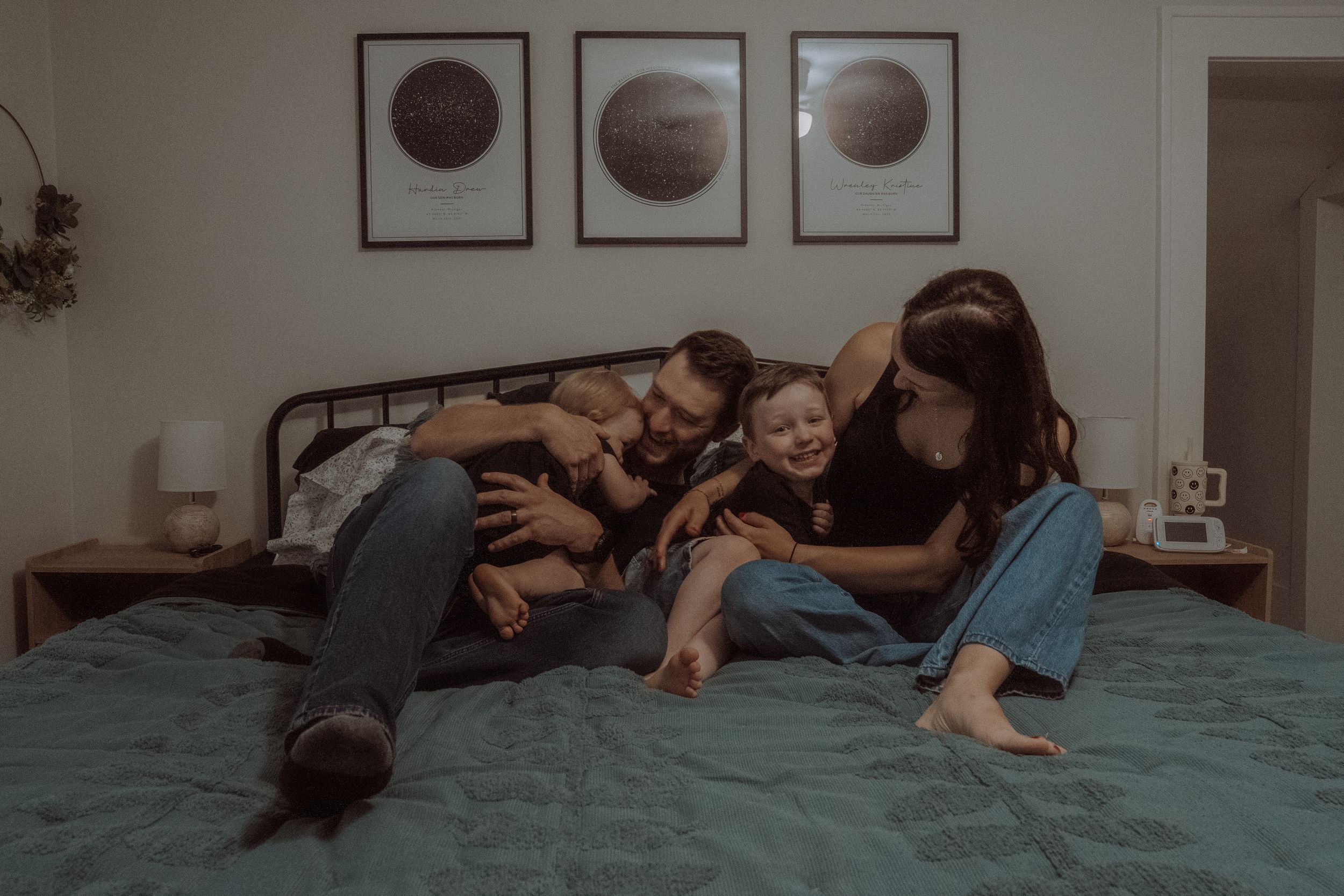 A sequence of four connected photos showing someone playfully rolling on a bed with their dog.
