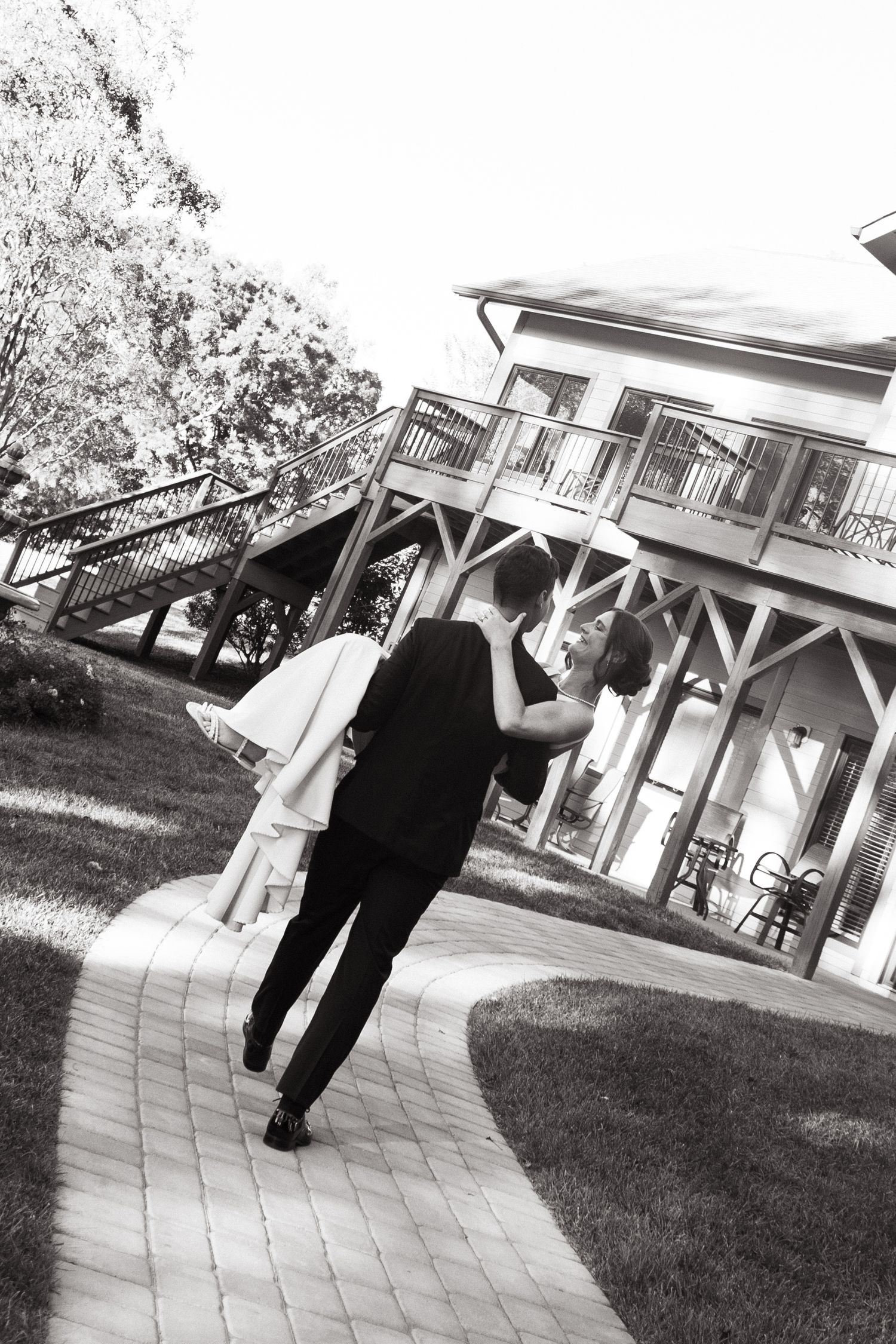 A sequence of four black and white photos showing a couple dancing together on a lawn in front of a gazebo.