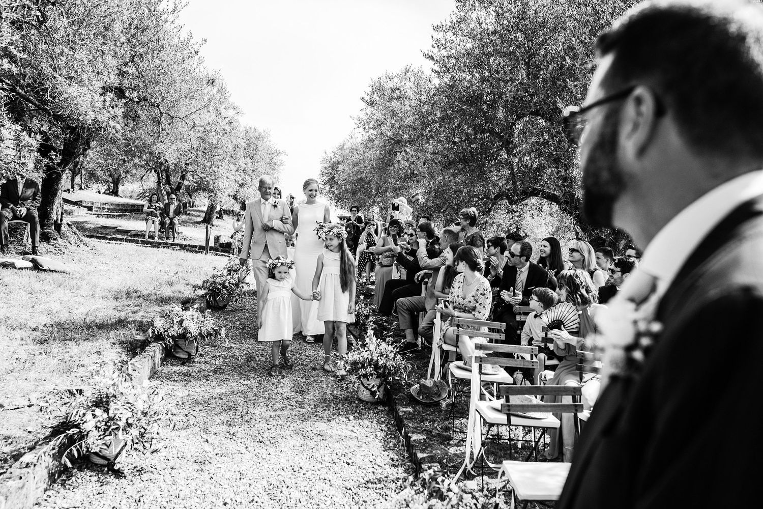 la mariée arrive à la cérémonie laïque dans un champ d'oliviers en Toscane