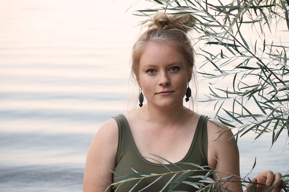 Teen girl standing in front of the Columbia River during senior portrait session in Richland WA