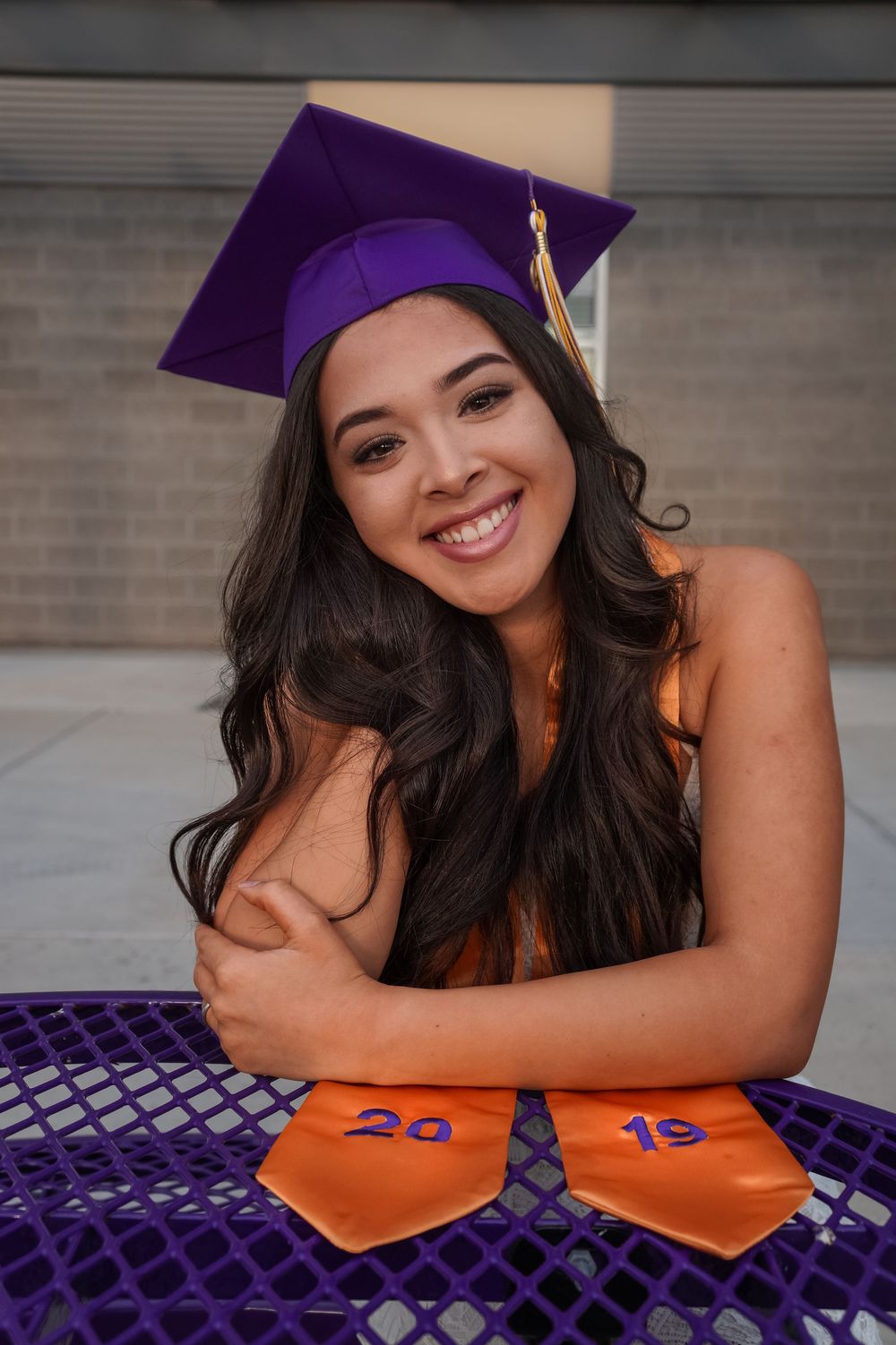 Graduating senior posing with diploma and smiling during senior session in Tri-Cities WA