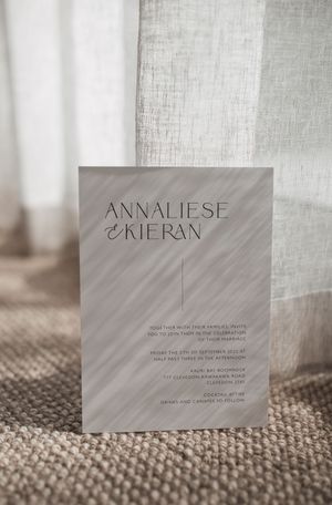 Elegant wedding name cards displayed on textured fabric with soft lighting and minimalist typography.