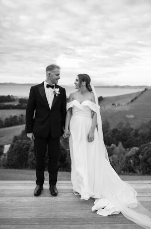 Intimate black and white wedding portraits captured on a rustic deck overlooking rolling hills.