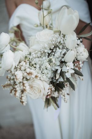 Delicate white floral bouquet with roses and baby's breath arranged in an elegant wedding style.