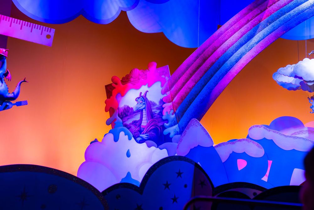 Abstract fluid art with vibrant blue and pink swirls against an orange background creates a dynamic cosmic effect.