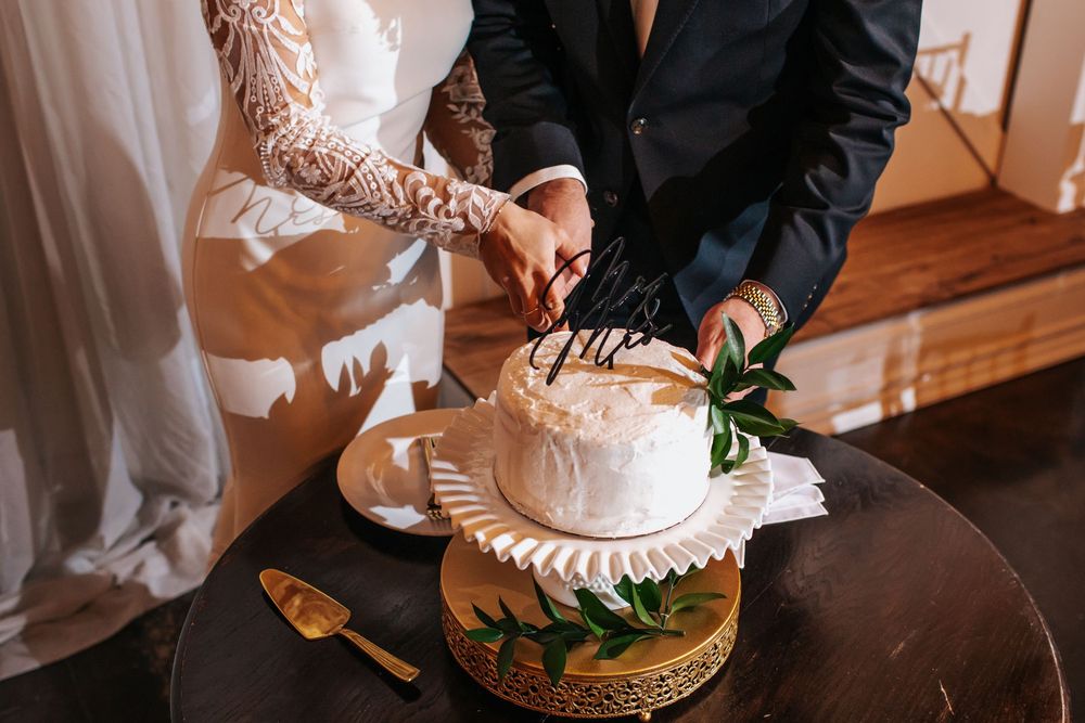 Close-up of wedding cake being cut during reception celebration.