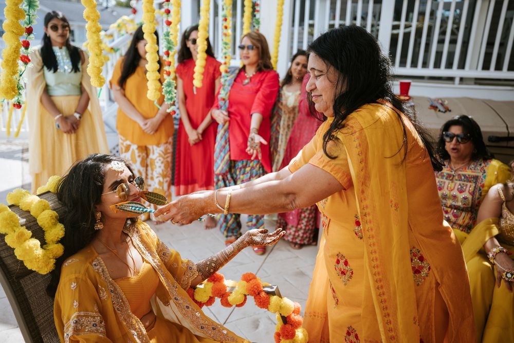 People celebrating an Indian wedding ceremony with yellow flower garlands and traditional attire.