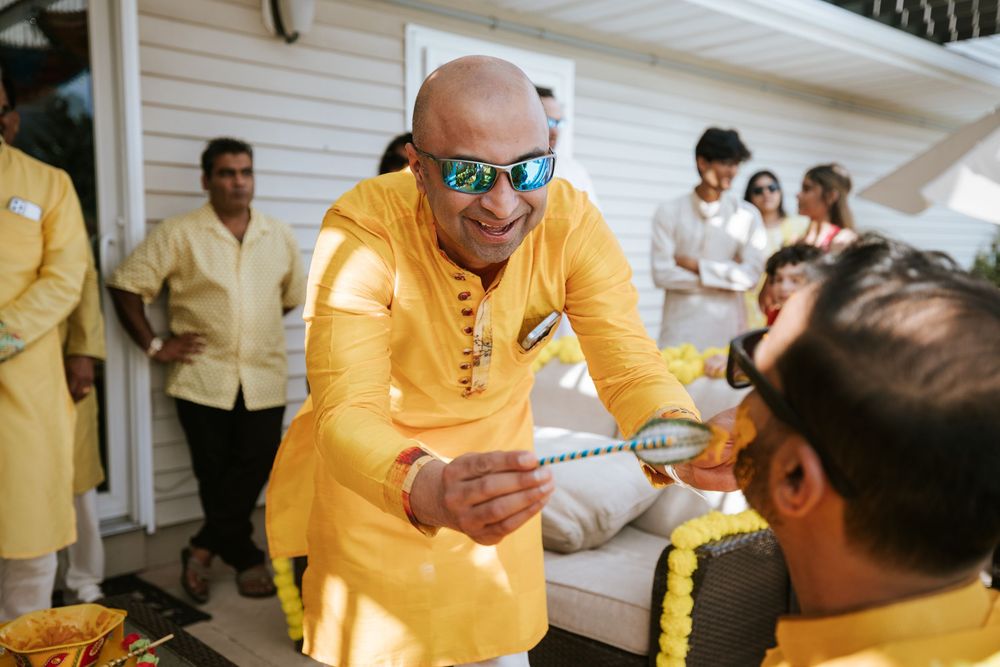 A person in a bright yellow outfit interacts with others on a porch of a white building.