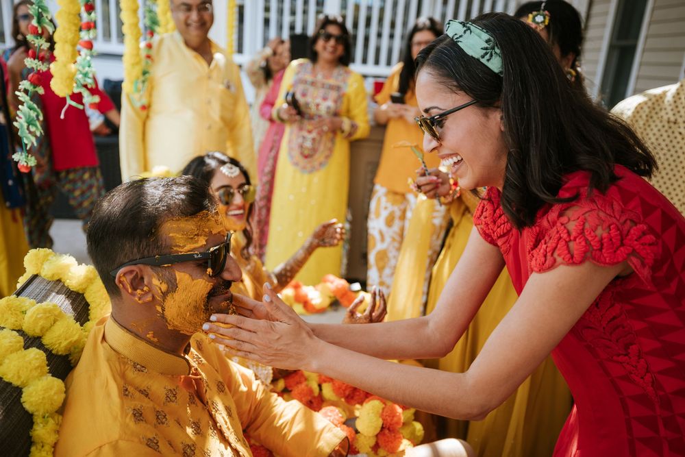 A group of people in red and yellow attire celebrating at a festive indoor gathering.
