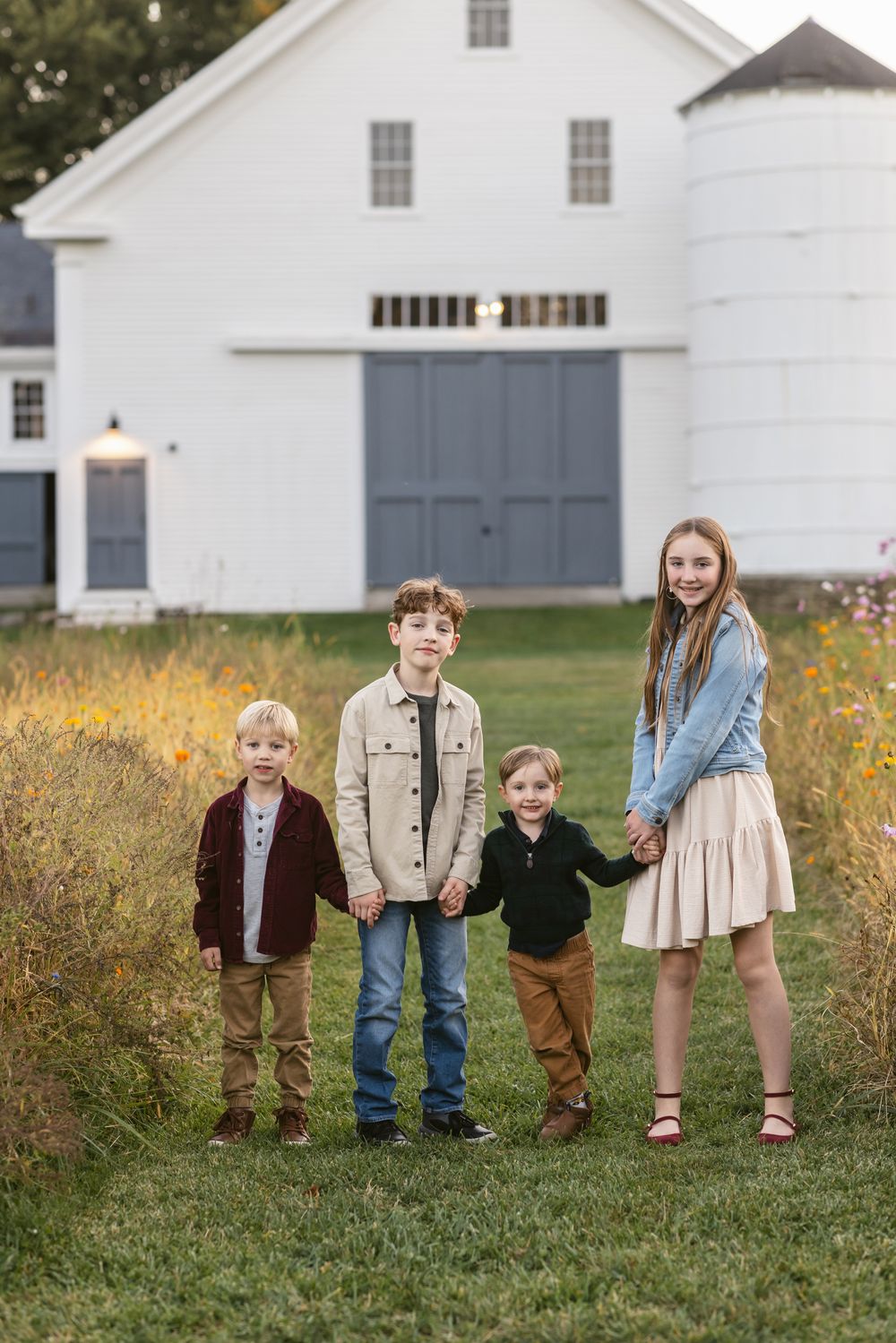 Children pose for family photos in front of the pastel blue door at Saltonstall Farm in Stratham, New Hampshire, Seacoast region.