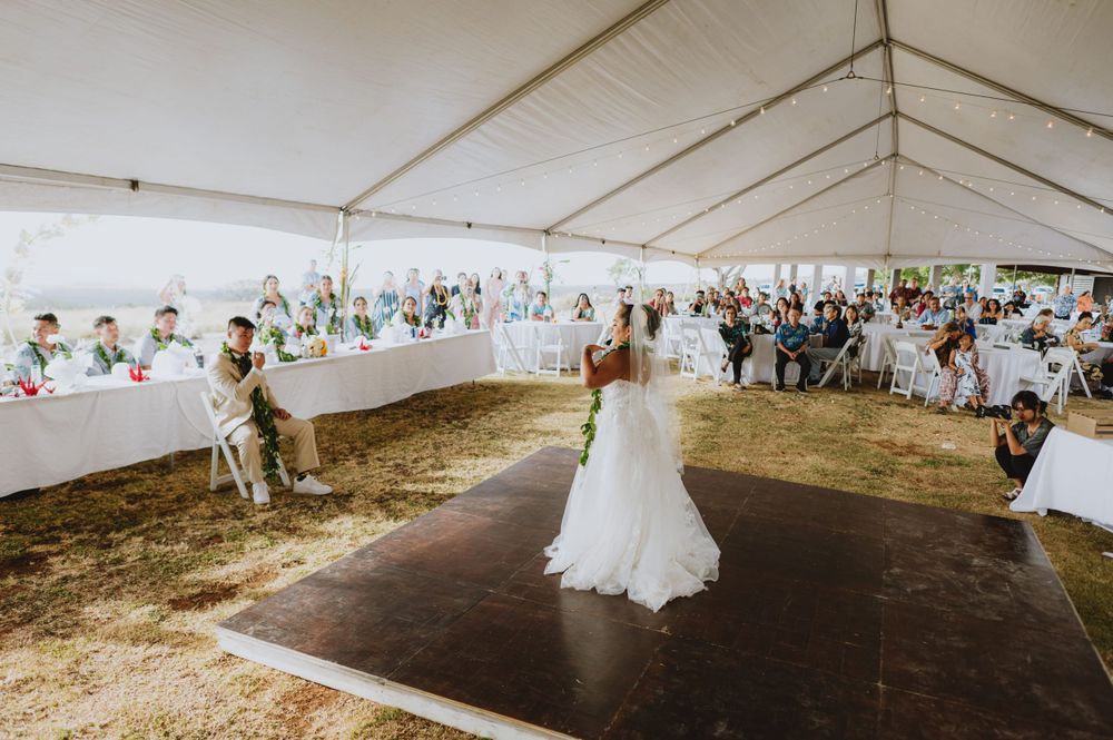 Wedding reception setup inside a large white tent with tables and dance floor.