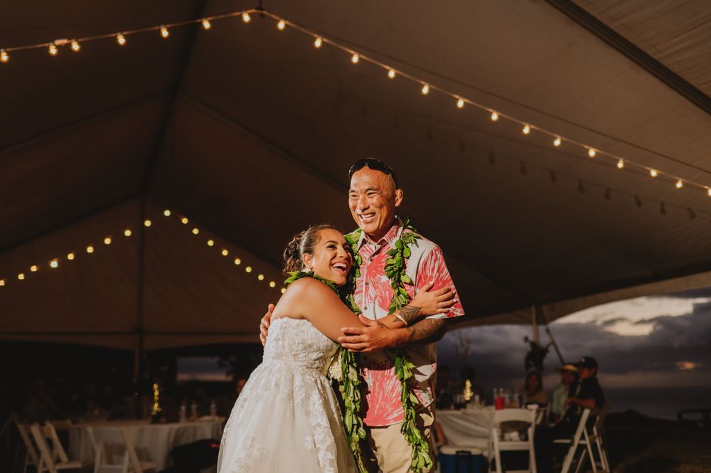 Couple embraces during sunset dance at their outdoor tented wedding reception.
