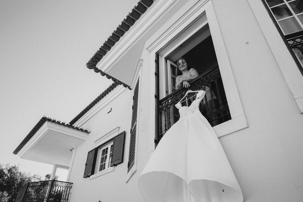 Black and white architectural detail showing a series of white shuttered windows and balconies against a light colored wall.