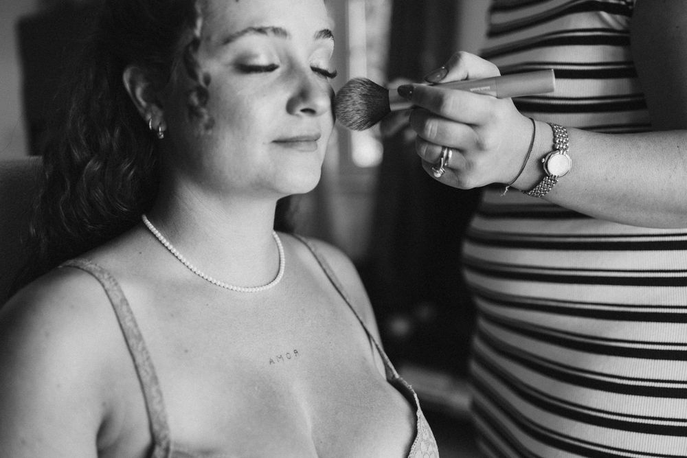 A close-up black and white portrait showing someone wearing a pearl necklace and looking to the side.