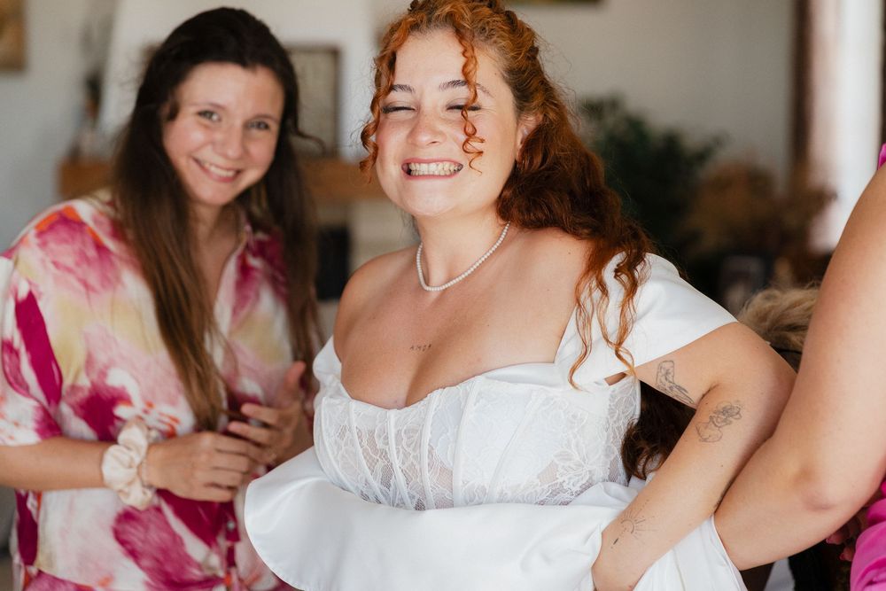 Bride getting ready with bridesmaids in pink dresses during wedding preparations.