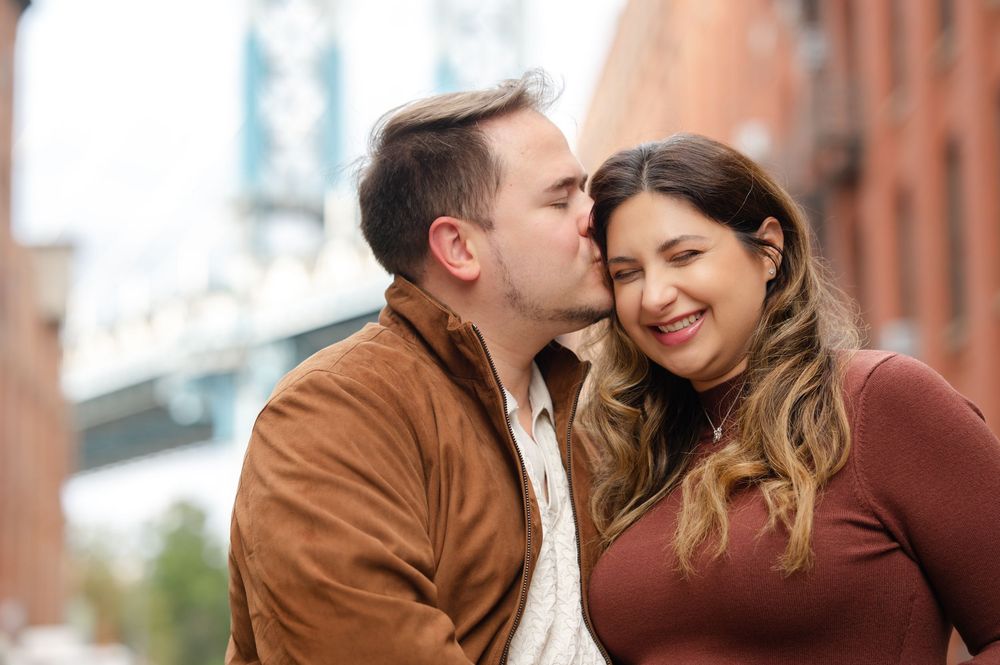 Romantic couple in burgundy sweaters share tender moments while walking in an urban setting during autumn.