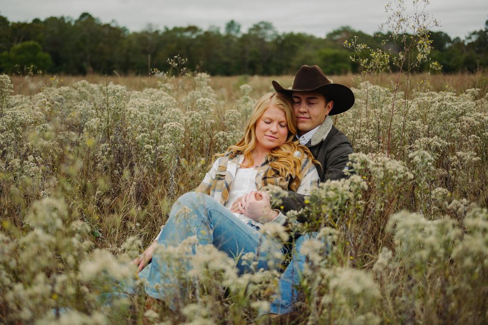 A romantic moment captured in a wildflower field on an overcast day.