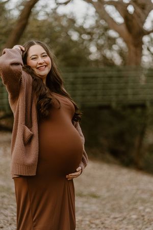 Autumn outdoor photoshoot featuring brown sweater against natural backdrop.