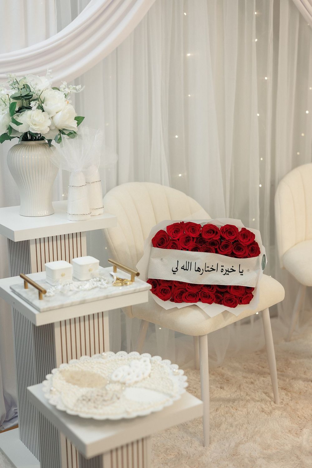 White modern interior setup with elegant chairs and red rose arrangements on display.