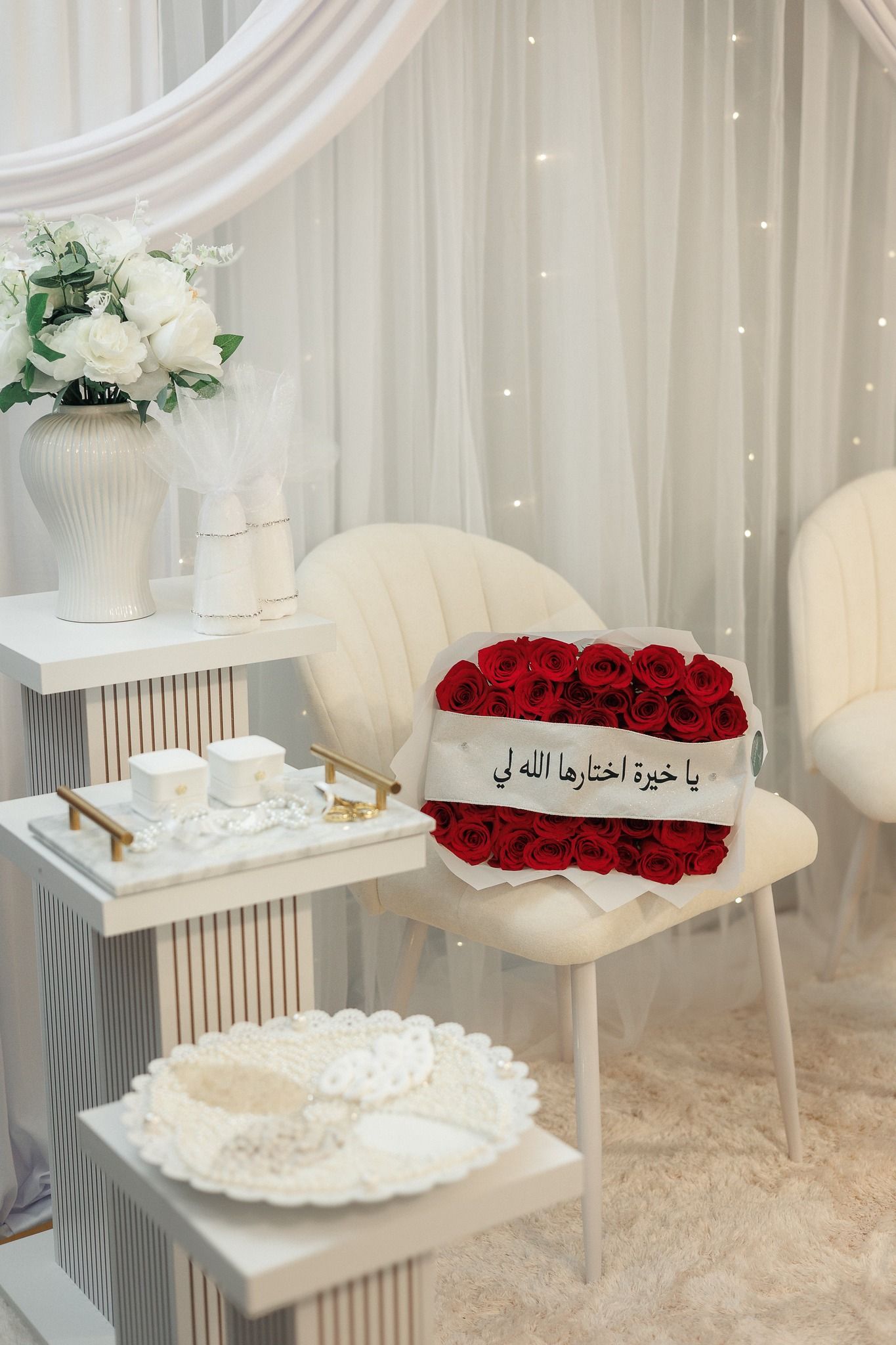 White modern interior setup with elegant chairs and red rose arrangements on display.