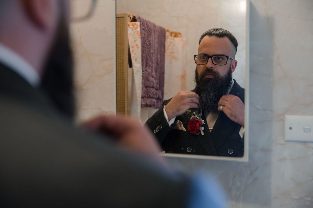 Groom getting ready in front of the mirror minutes before the ceremony at a private country home in Rural NSW
