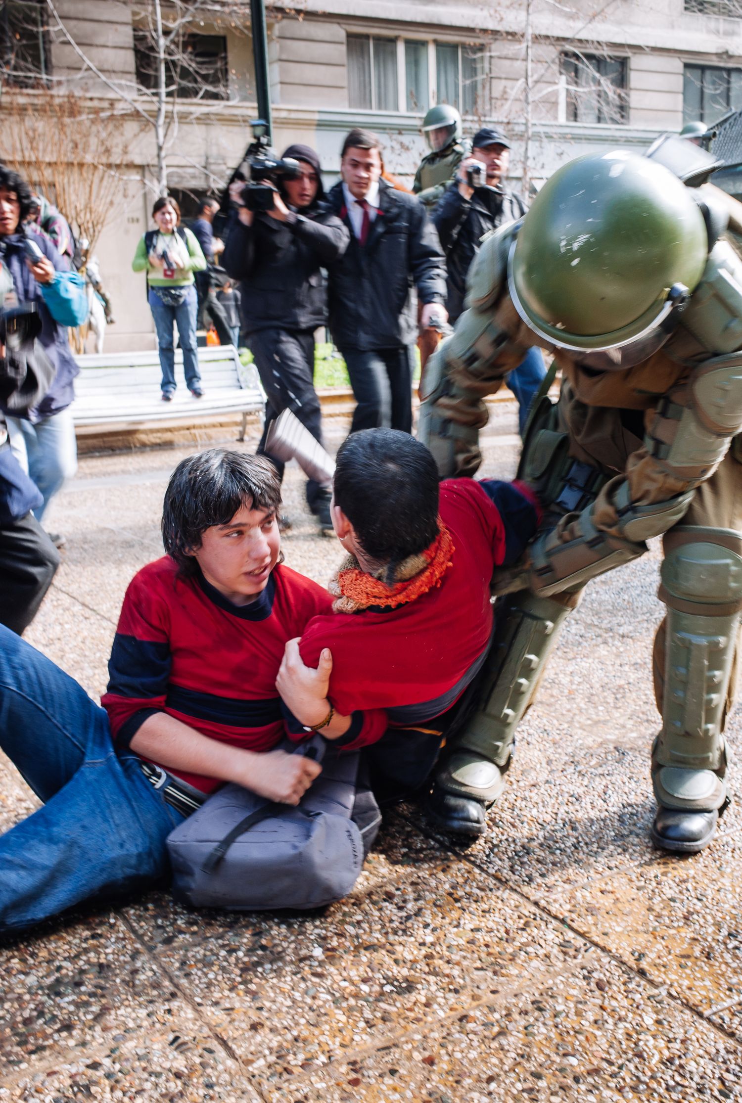 Police in riot gear arresting protesters on the ground during a street demonstration for a fairer education system. Santiago, Chile