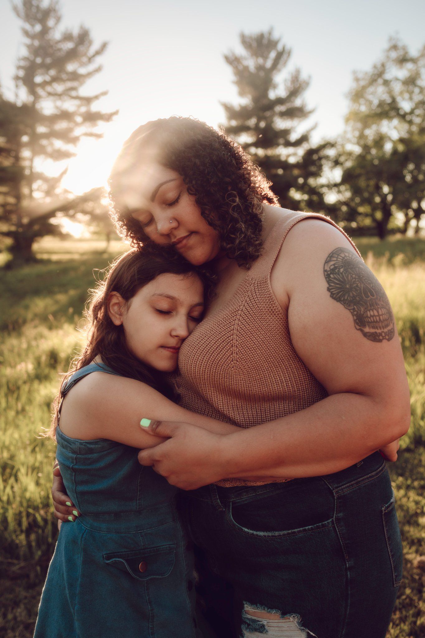 Intimate outdoor portrait session in a sunlit field with natural golden hour lighting.