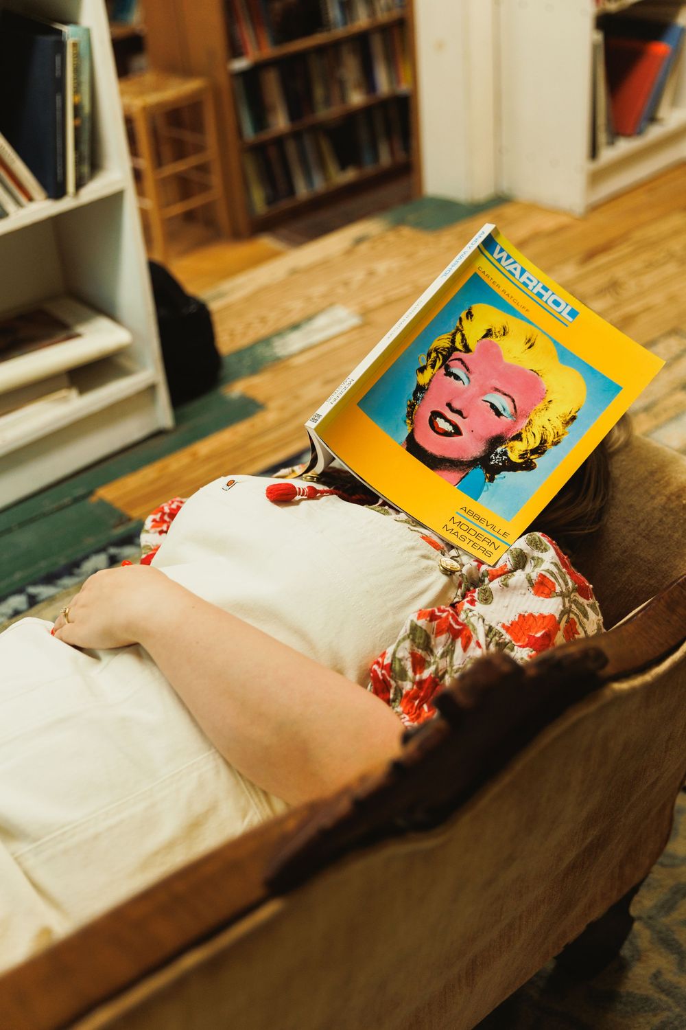 A yellow book cover visible on a couch with floral patterned fabric.