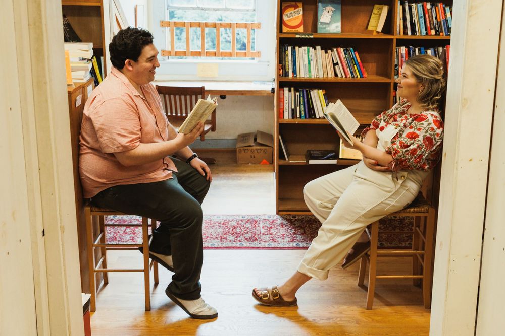 A library interior showing multiple angles of bookshelves and seating areas.