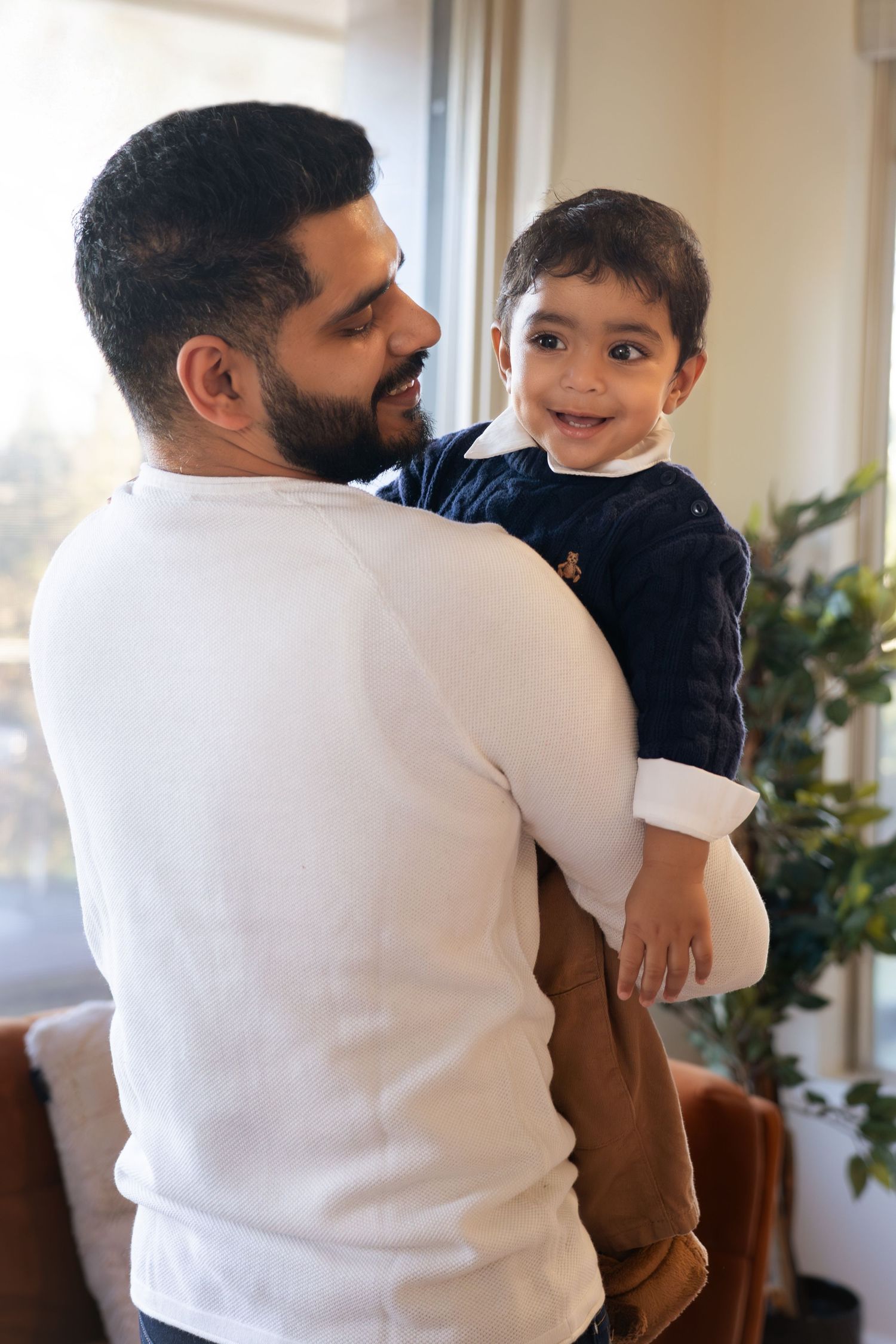 A series of four connected images showing tender moments between parent and child in a bright interior setting.