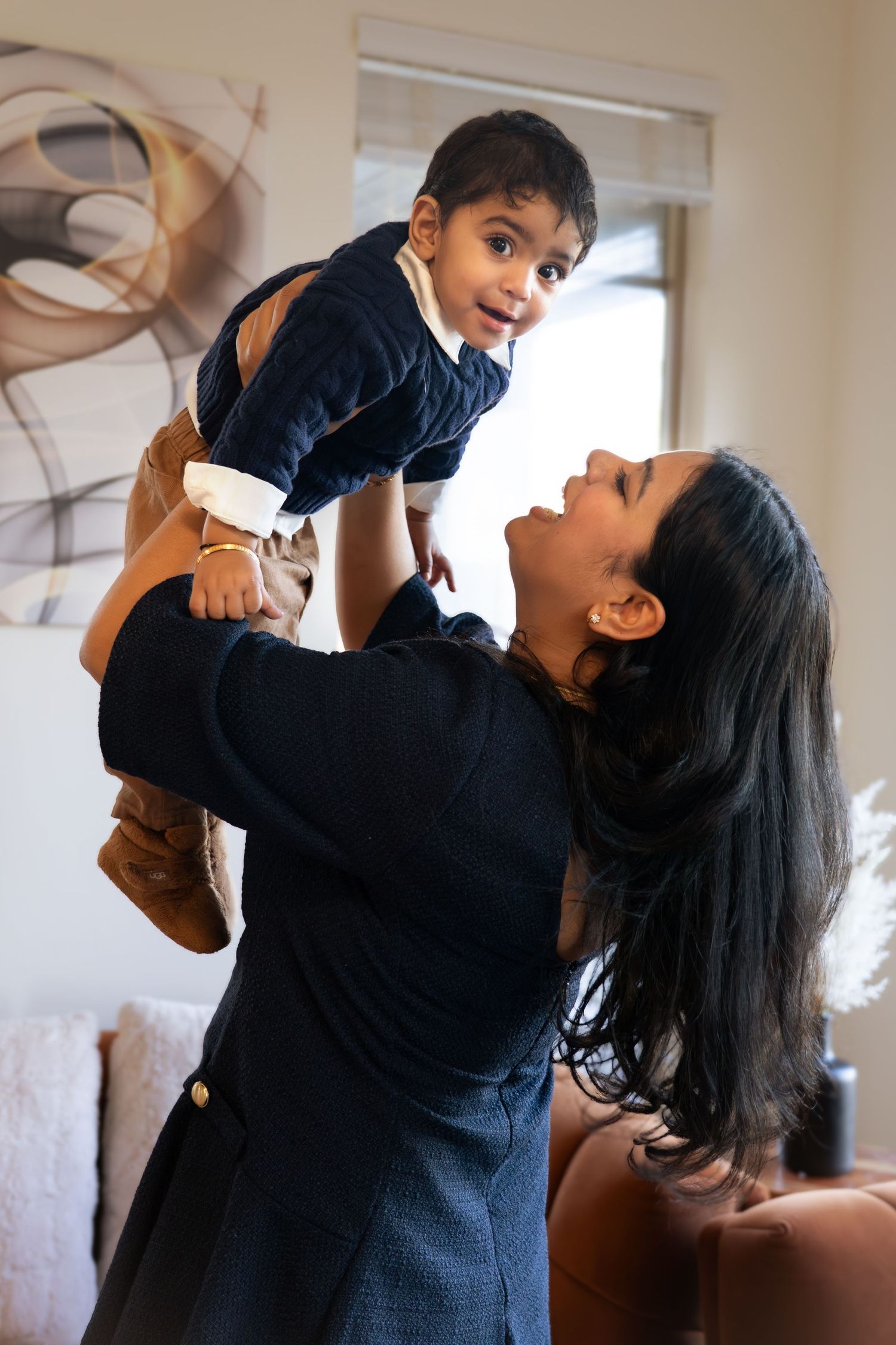 A sequence of four photos showing a parent lifting and playing with a small child in an indoor setting.