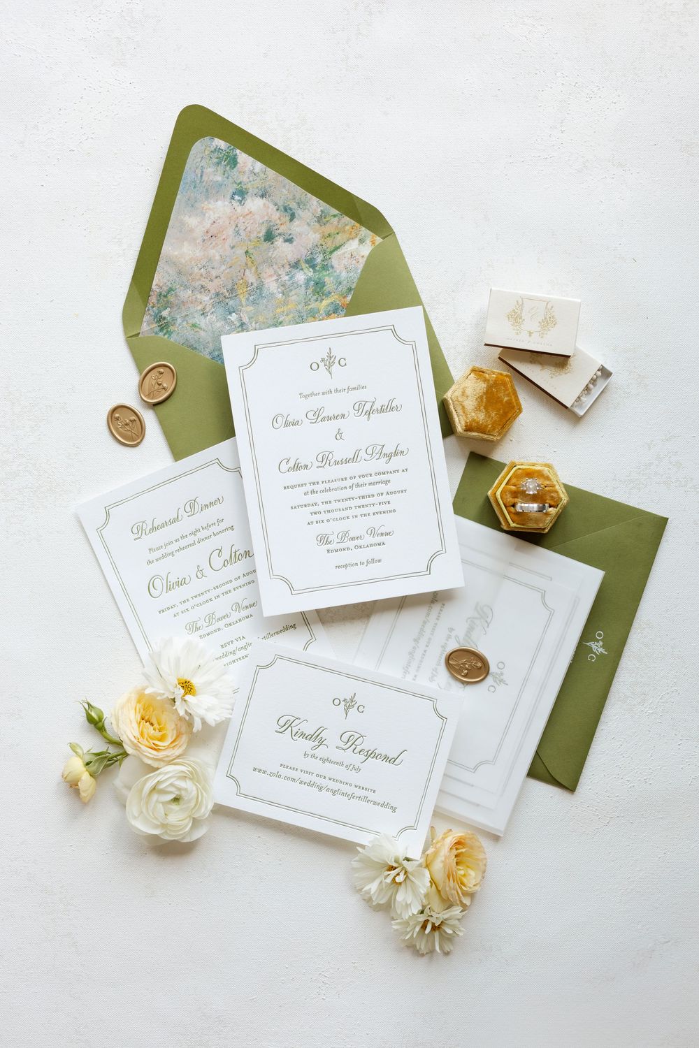 Elegant wedding invitation suite with green envelopes, wax seals, and fresh yellow and white roses.