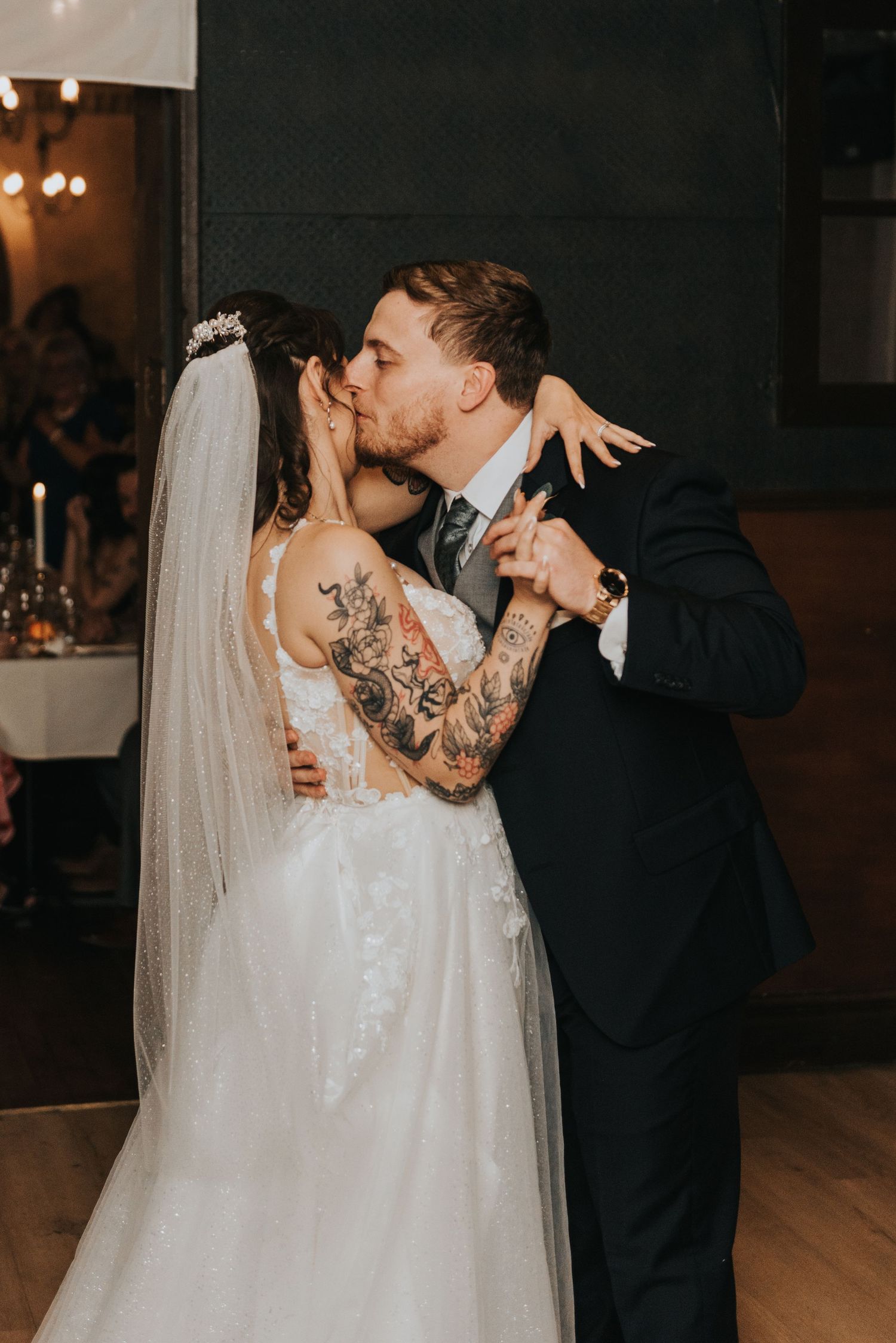 A romantic wedding couple shares intimate kisses in a sequence of dimly lit indoor reception photos.