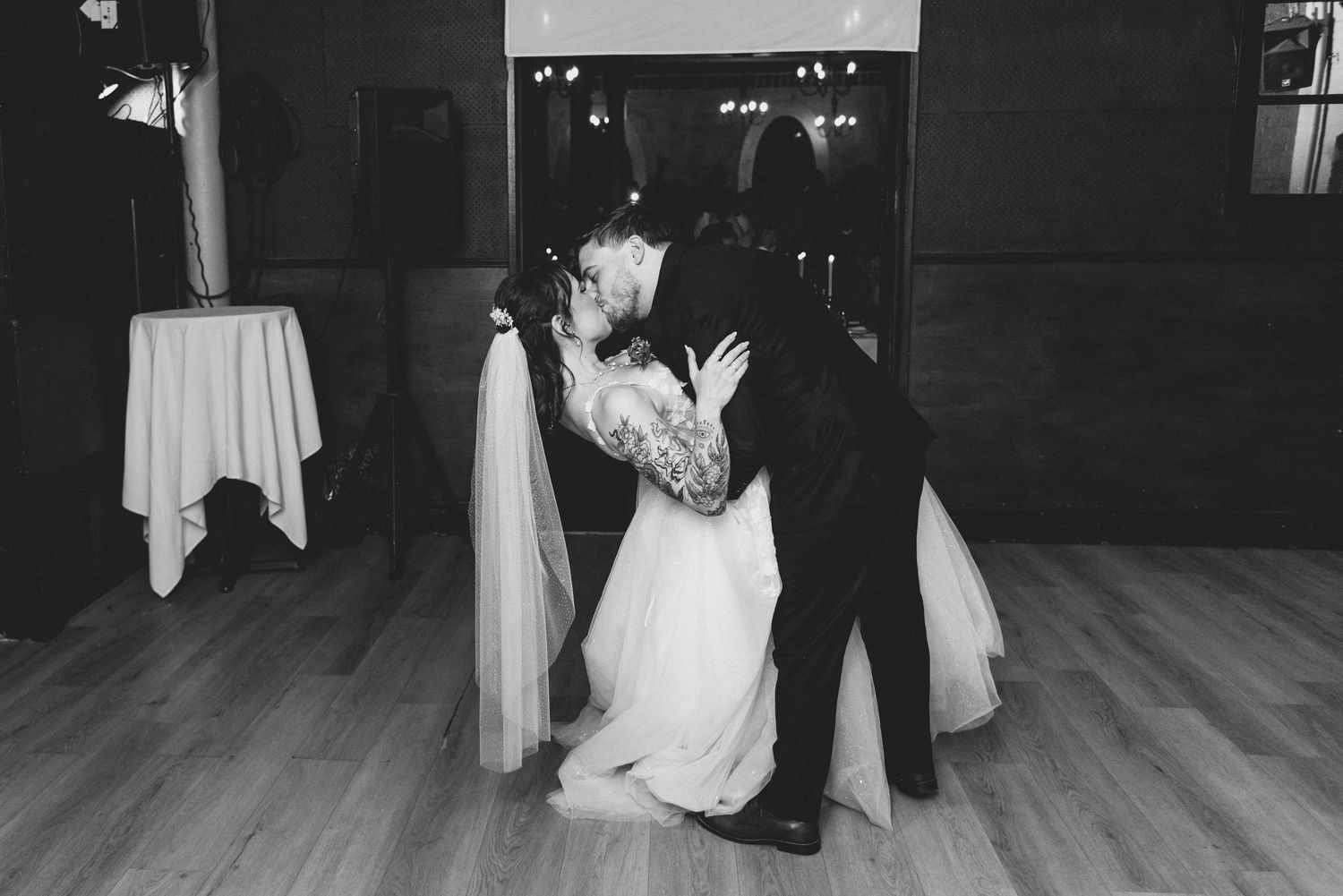Black and white photo series of a wedding couple dancing together on a wooden floor during their first dance.