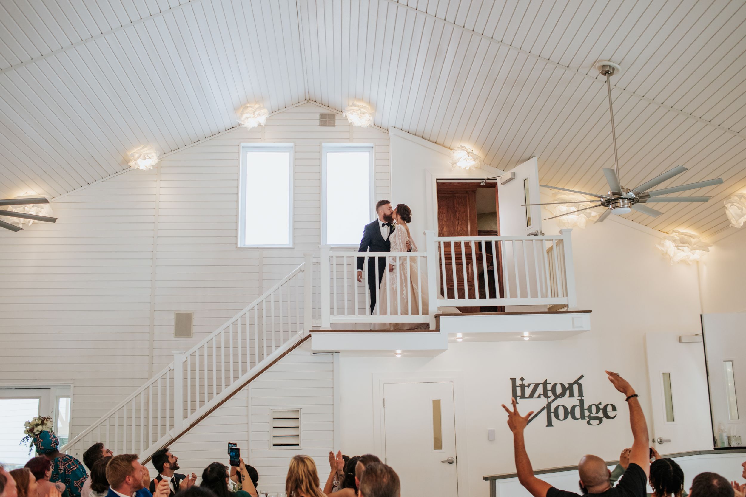Wedding celebration in a modern white chapel with vaulted ceilings and elegant lighting.
