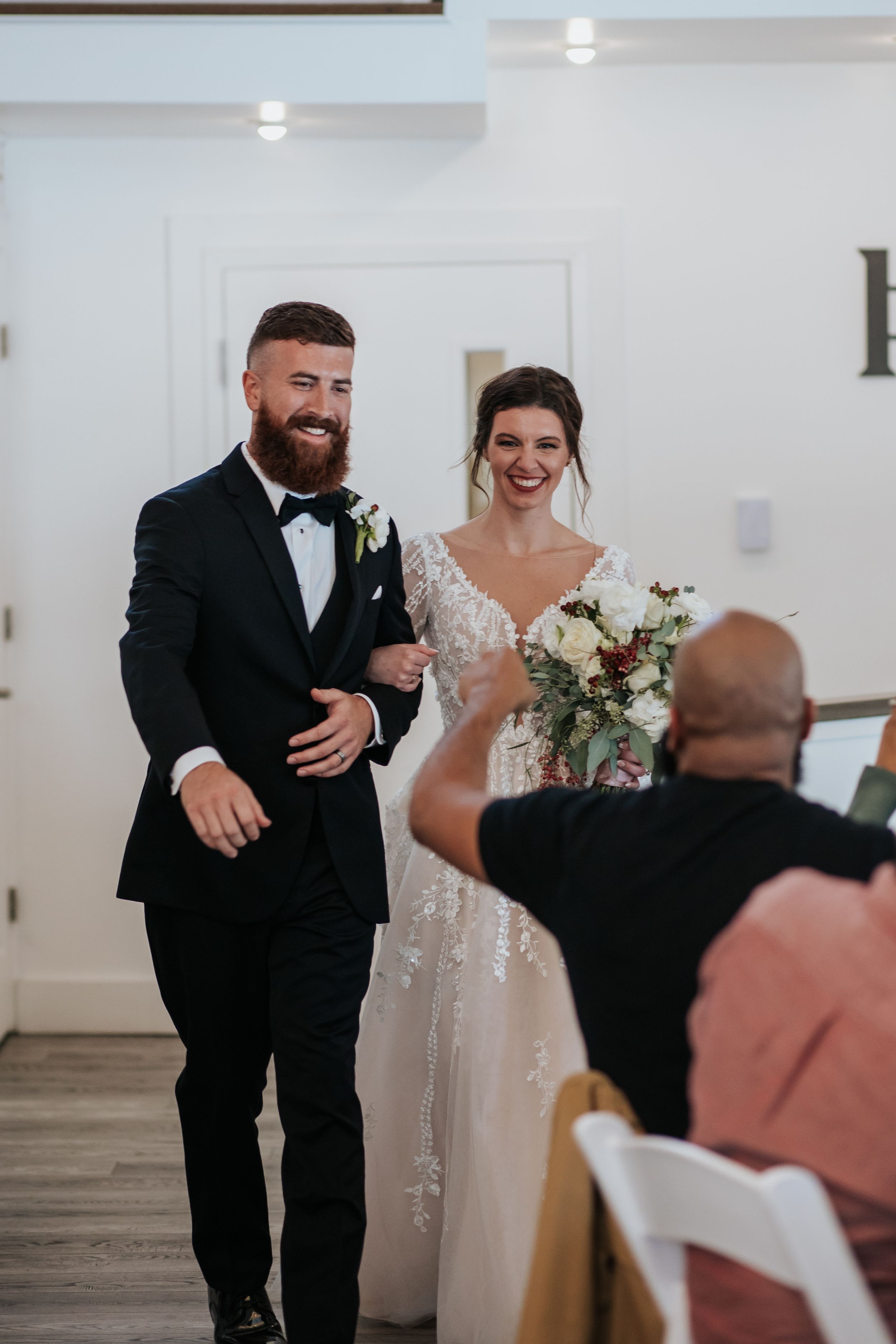 A celebratory entrance into a white-walled wedding venue with elegant decor.
