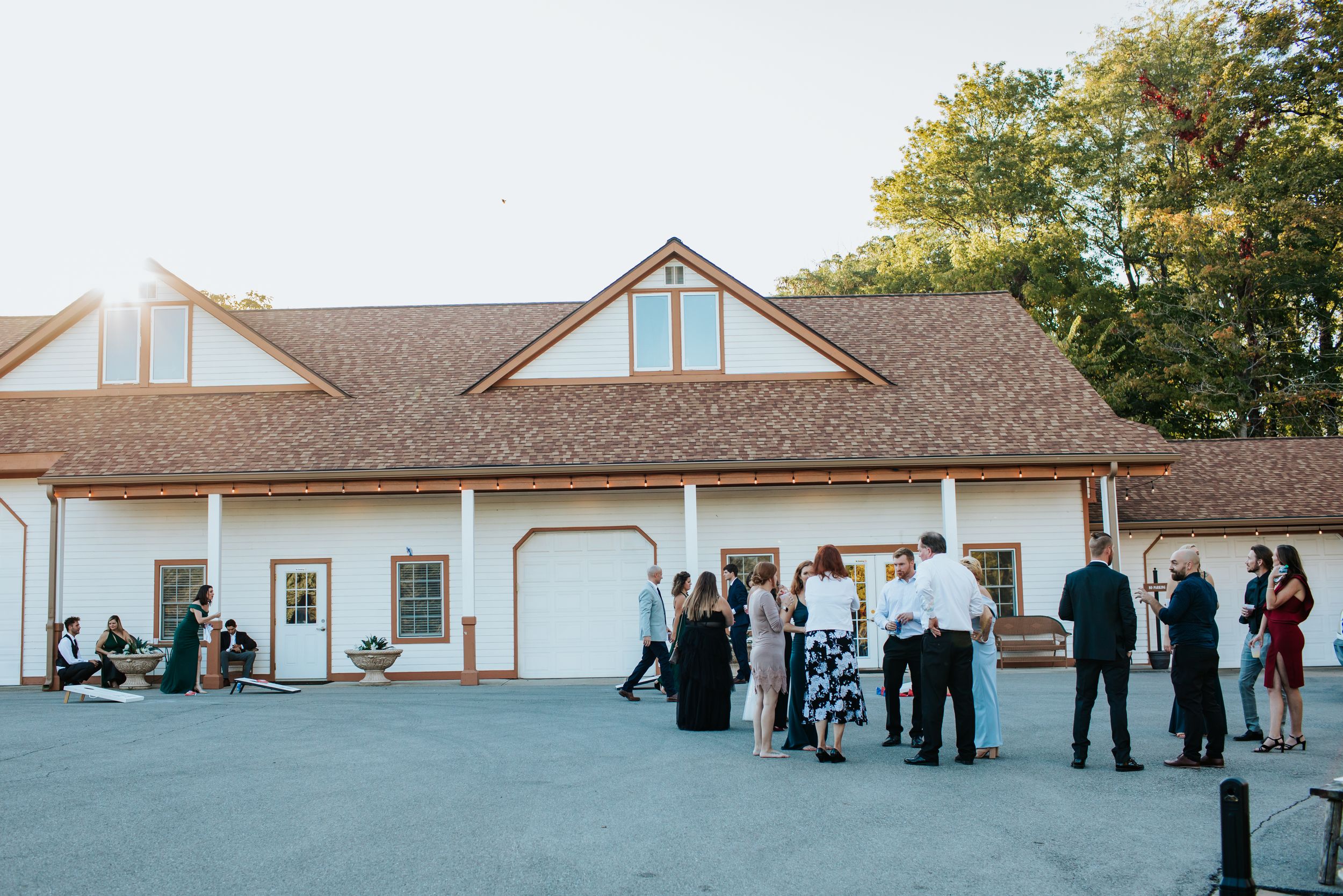 Exterior view of white church building with wedding guests gathering outside.