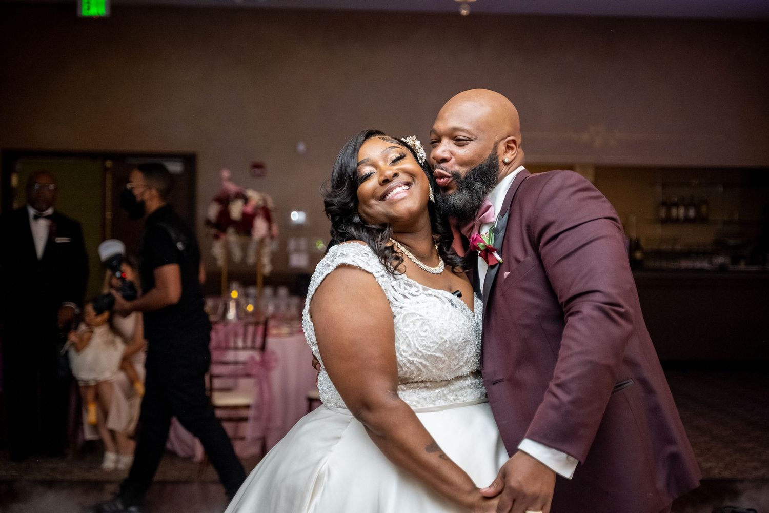 Bride and groom share a joyful first dance embrace at their elegant wedding reception venue.