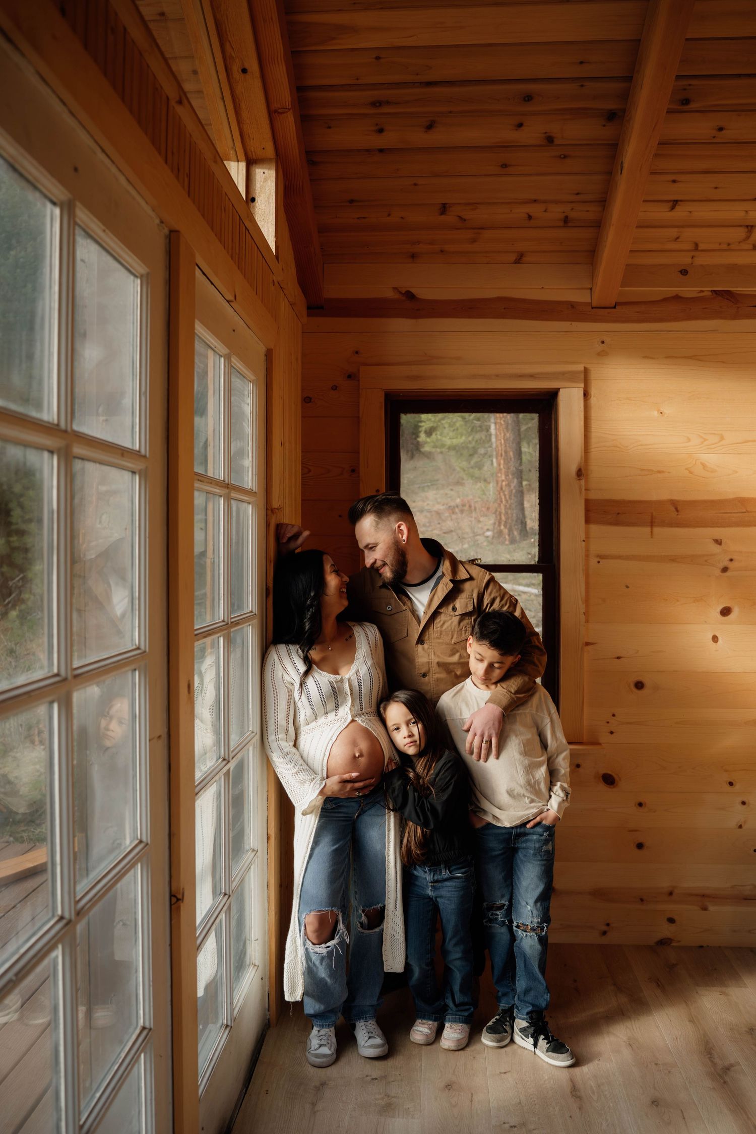 Black and white photo of a family with children gathered in a cozy kitchen, sharing a warm moment together.