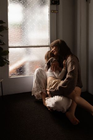 mum holding her daughter close and cuddling in