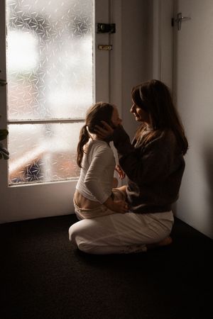 mum holding daughters face, admiring her