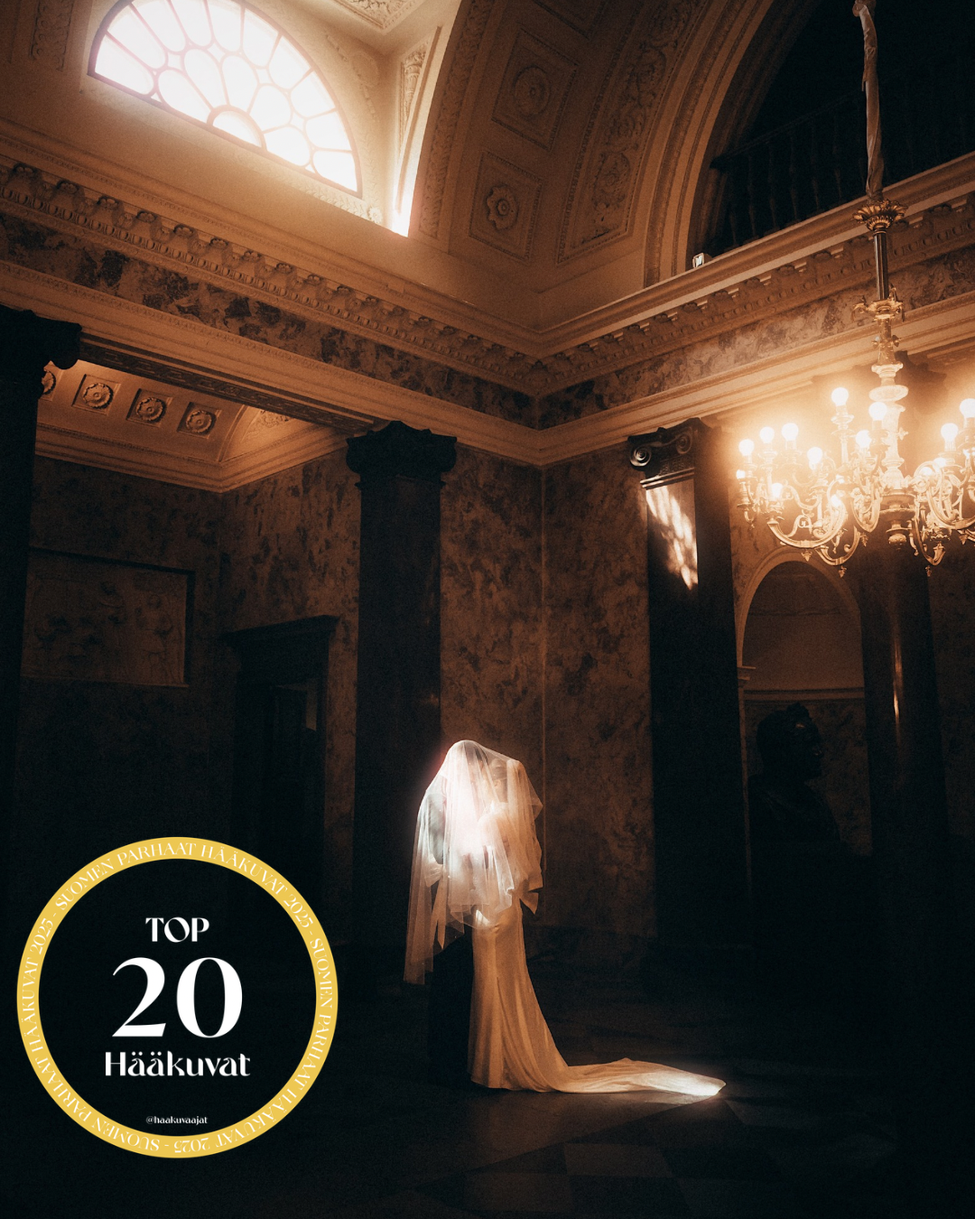 Bride in wedding dress and veil standing in dramatic light inside an ornate hall, Top 20 Häätuvat award.