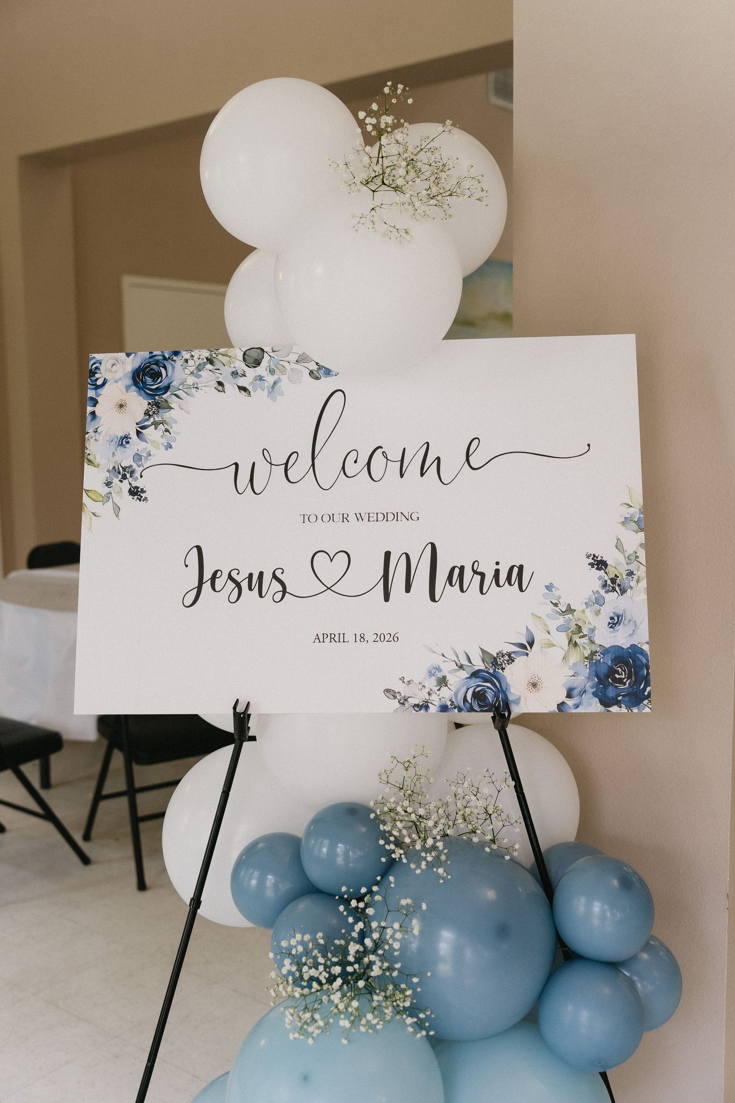 Wedding welcome sign for Jesus and Maria on April 18, 2026, decorated with blue floral accents and balloon garland.