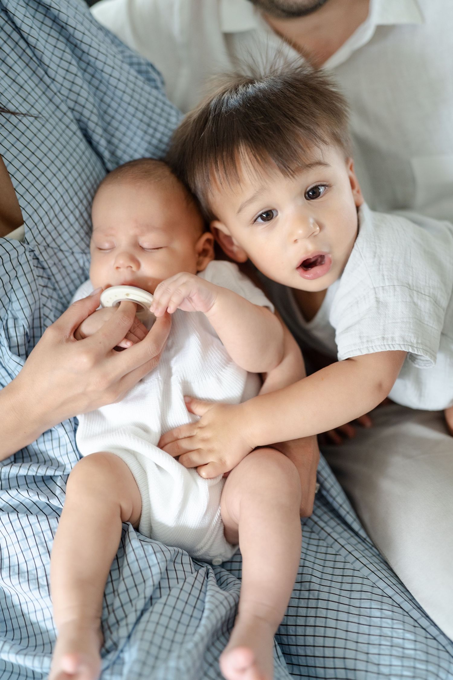 Toddler hugging newborn baby brother