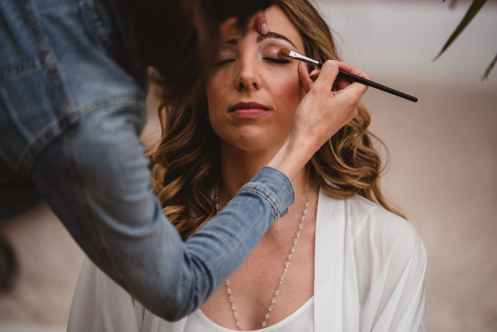 Behind the scenes preparation shots showing makeup application in soft lighting.
